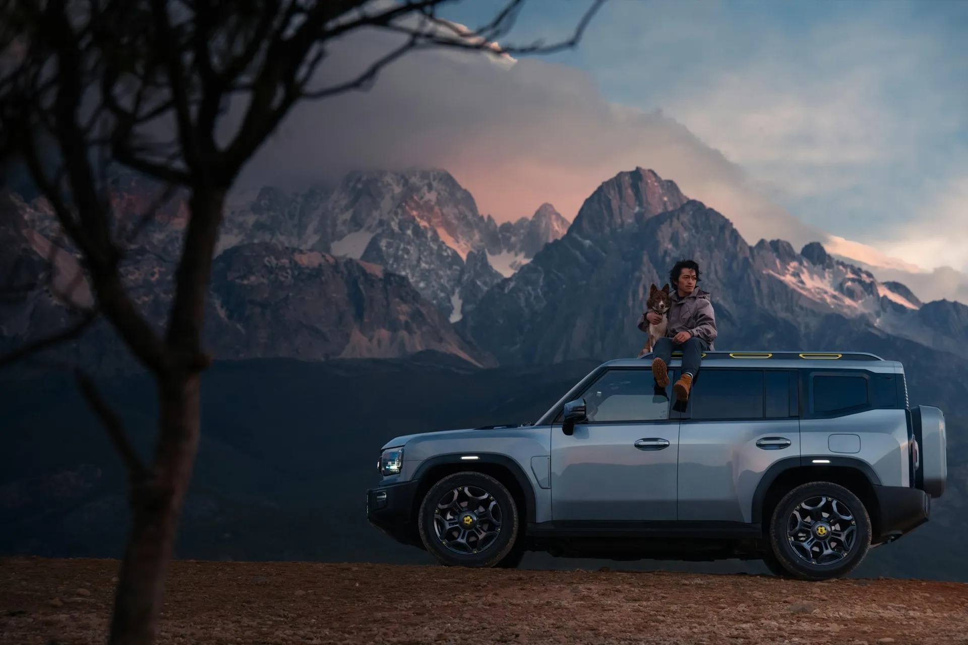 Person overlooking mountain range from vehicle rooftop at sunset — representing the vantage point your business achieves with a high-performance website